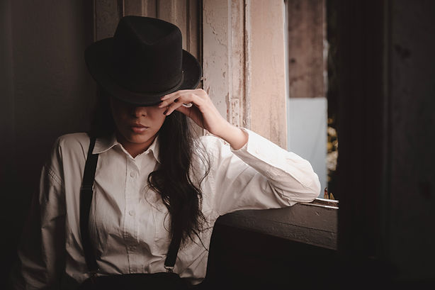 Mulher com roupa de época segurando um capeu