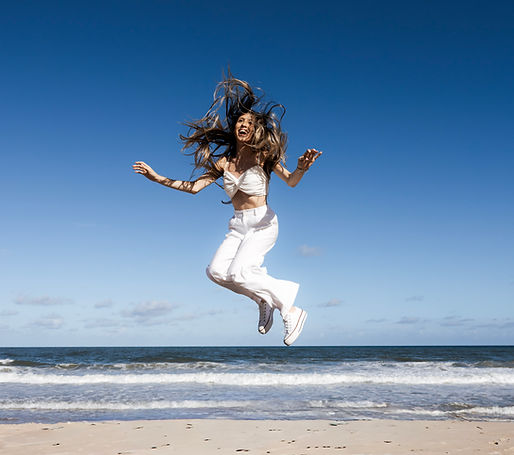 mulher em salto de trampolim na praia 