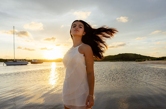 debutante com cabelos ao vento na beira mar