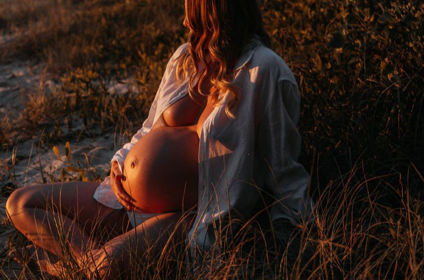 Woman holding her pregnant belly after preparing for pregnancy with preconception care understanding 90-day egg maturation window