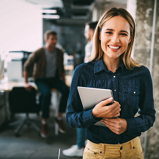 Happy employee smiling at the camera with a tablet in her arms.