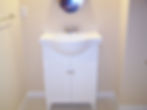Small white bathroom vanity with round sink and cabinet
