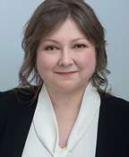 a photo of Elena Cavallo wearing a white blouse and a dark blue jacket