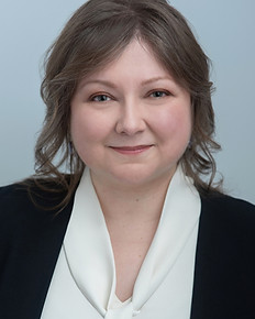 a photo of Elena Cavallo wearing a white blouse and a dark blue jacket