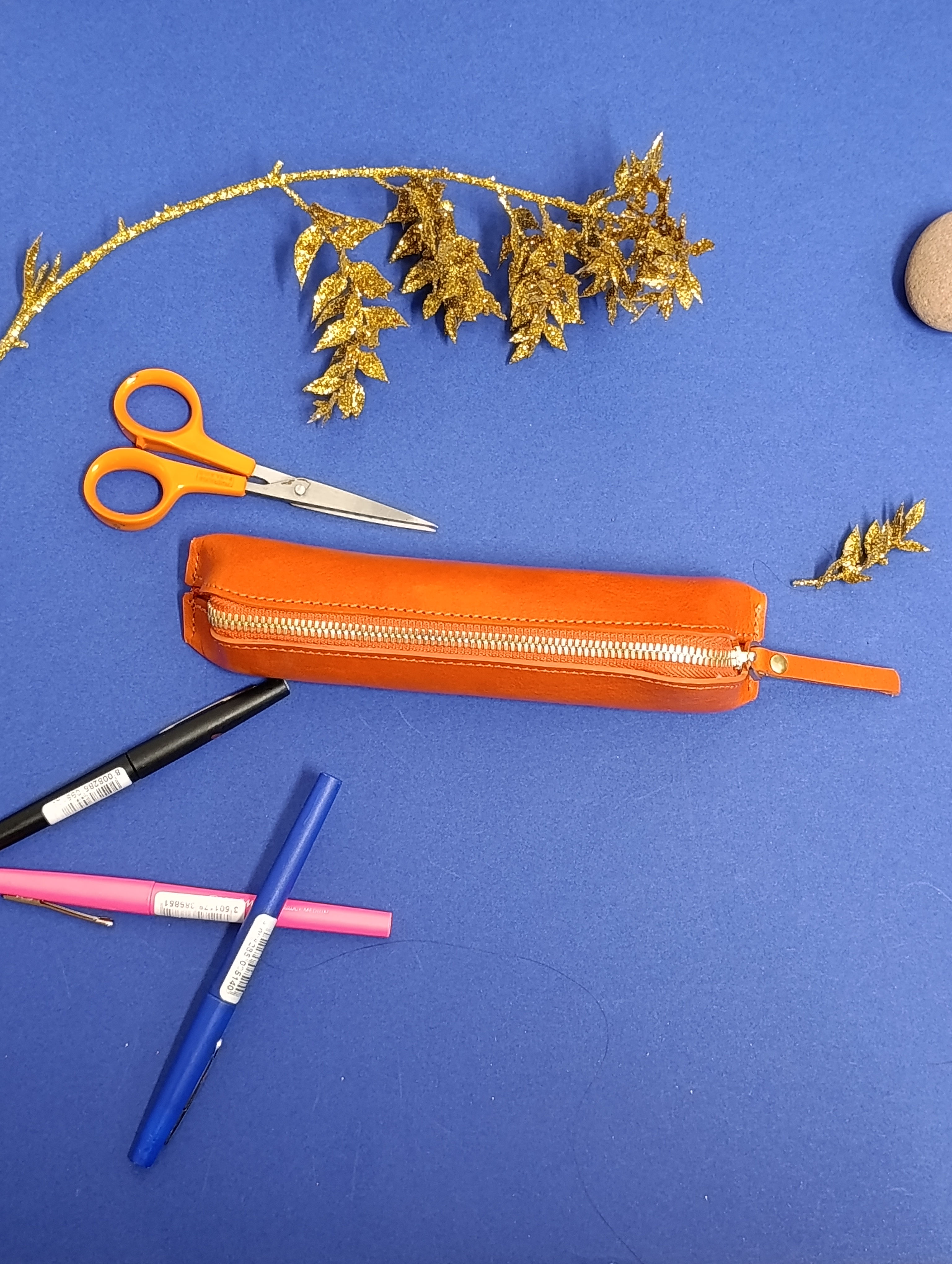 trousse en cuir orange triangle qui tien debout