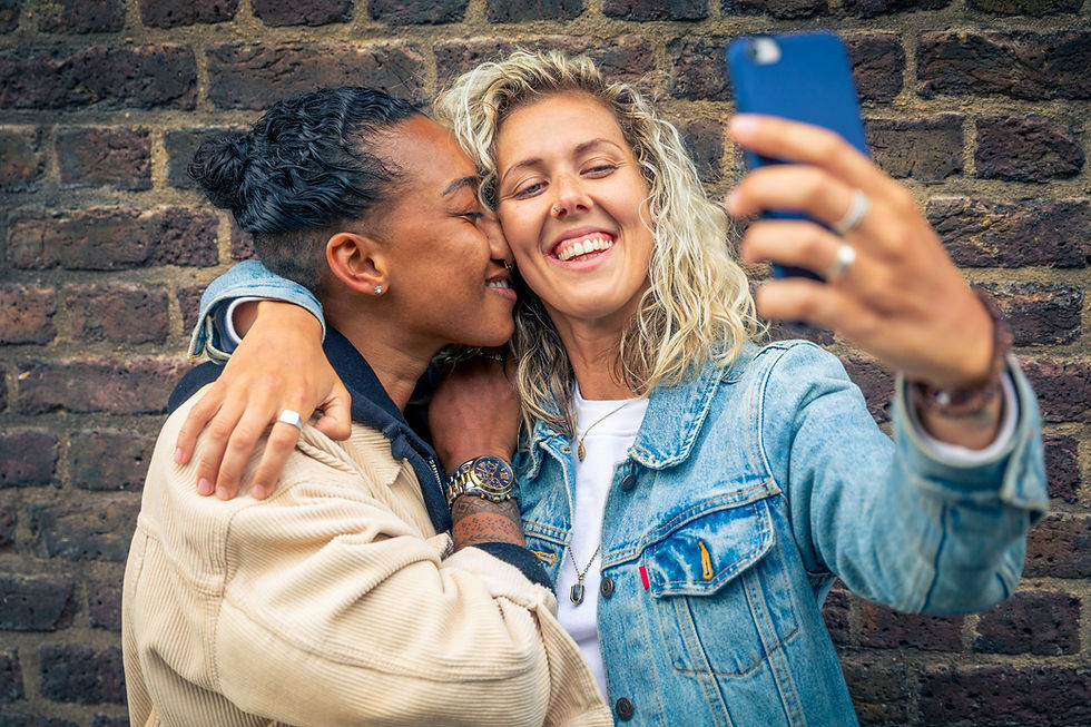 Happy friends holding each other and taking selfie