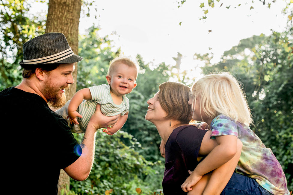 family standing together as baby looks at camera