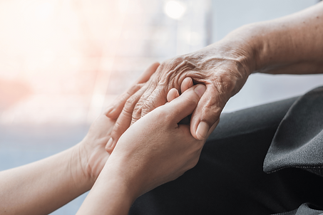 A carer holding an elderly persons hand