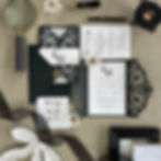 Laser cut black wedding invitation with ornate monogram pocket