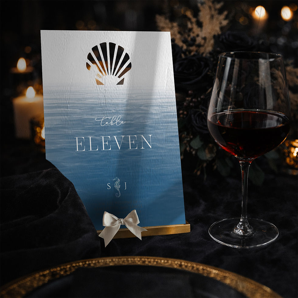 Blue coastal wedding table number with laser cut shell detail and elegant white typography