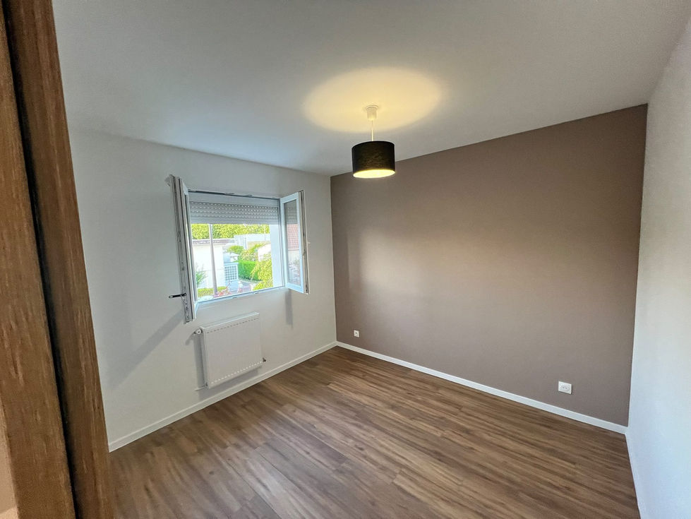 Chambre rénovée avec parquet, peinture murale et finitions intérieures