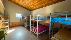 Sovsal med våningssängar, fönster och träpanel, Equillet Ridläger i Barcelona.