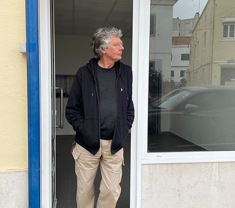 O artista de pé �à porta do seu estúdio.