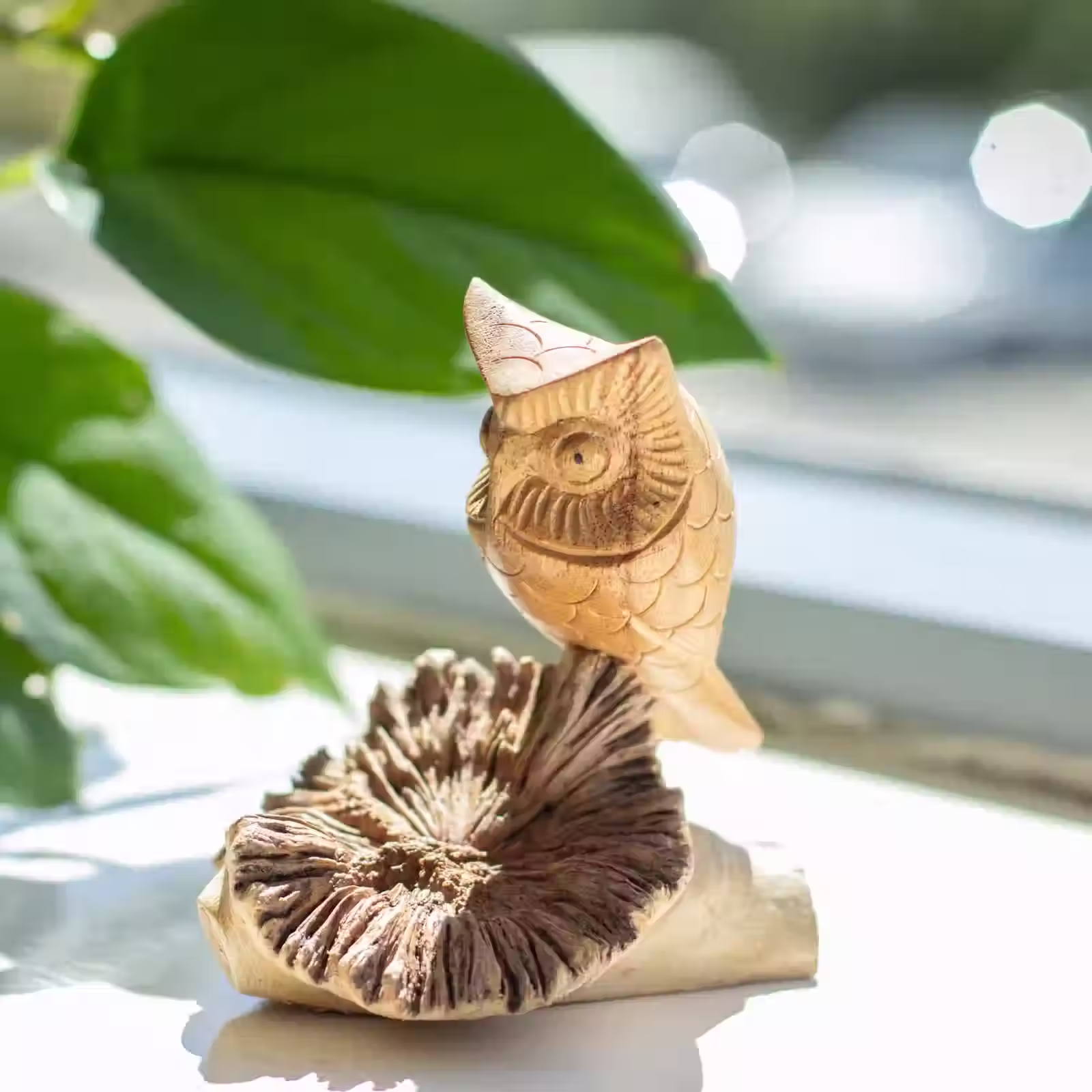 Hand carved wooden owl sitting on a piece of parasite wood