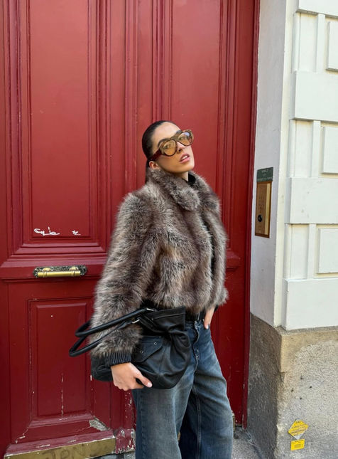 Woman in fur coat and sunglasses by red door