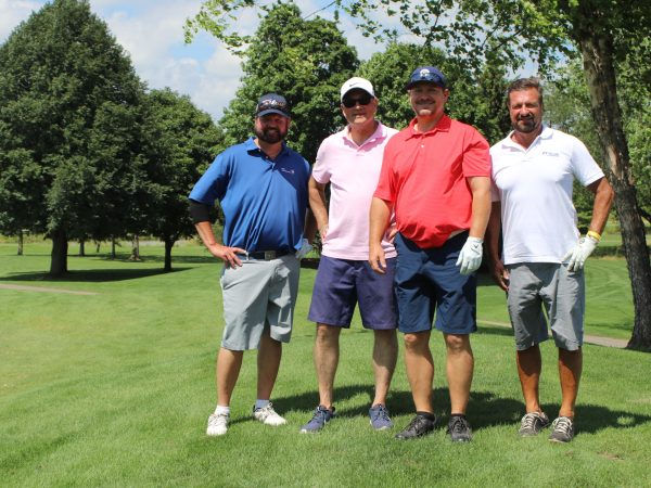 Four men standing on a golf course