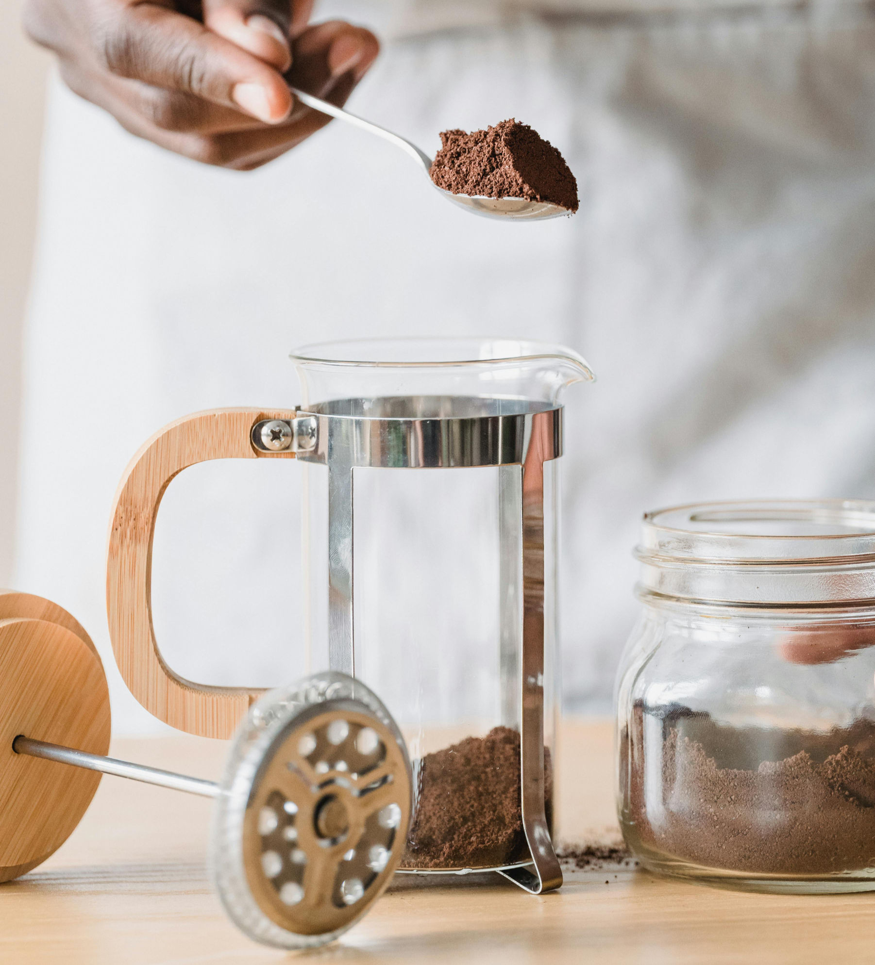 Man scooping coffee grounds into French press