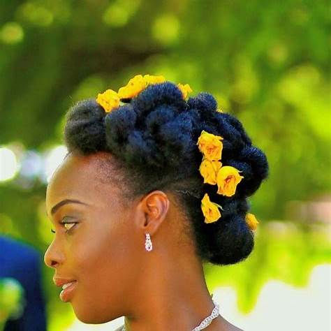 Coiffure de mariage afro avec un chignon bas tressé, sublimé par des accessoires décoratifs en perles, idéale pour un look raffiné et chic
