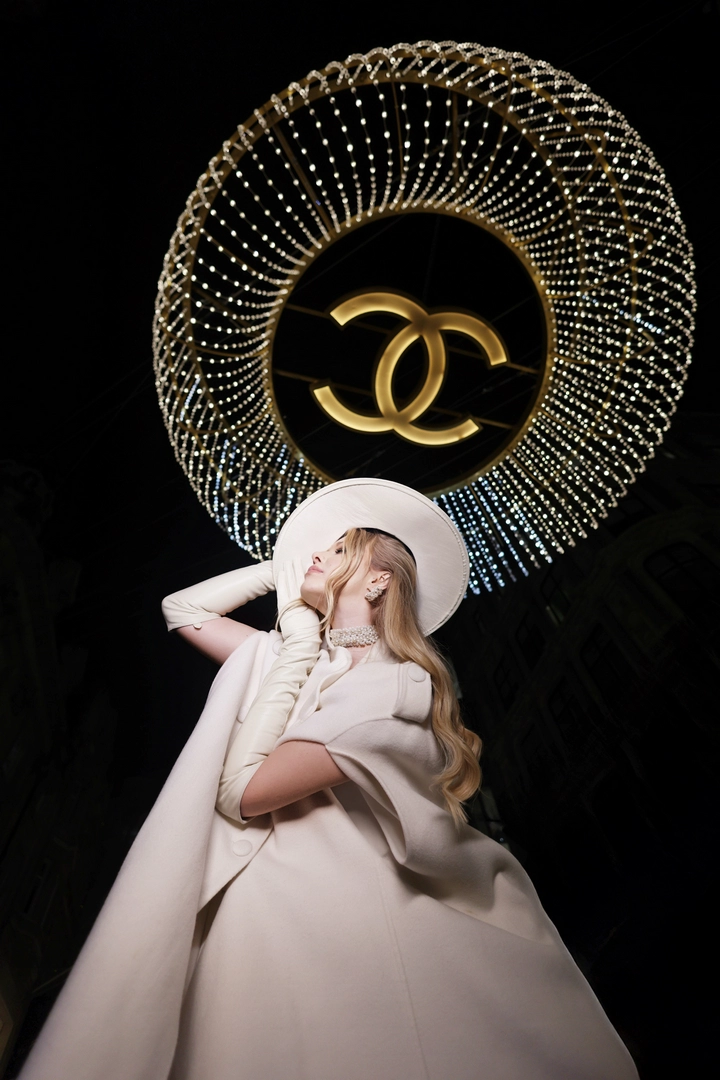 A girl posing by the chanel chandelier