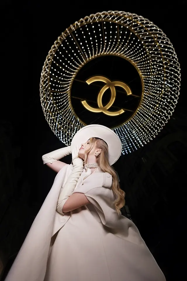 A girl posing by the chanel chandelier