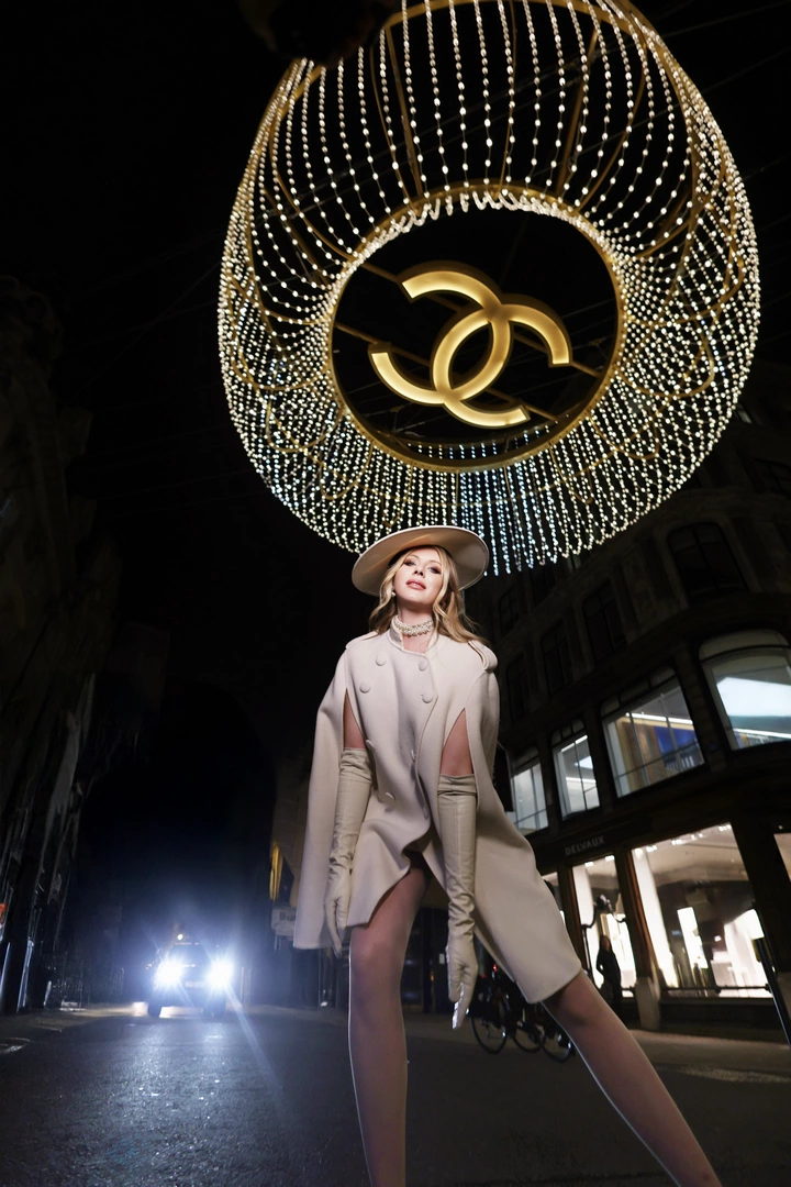 A girl posing by the chanel chandelier