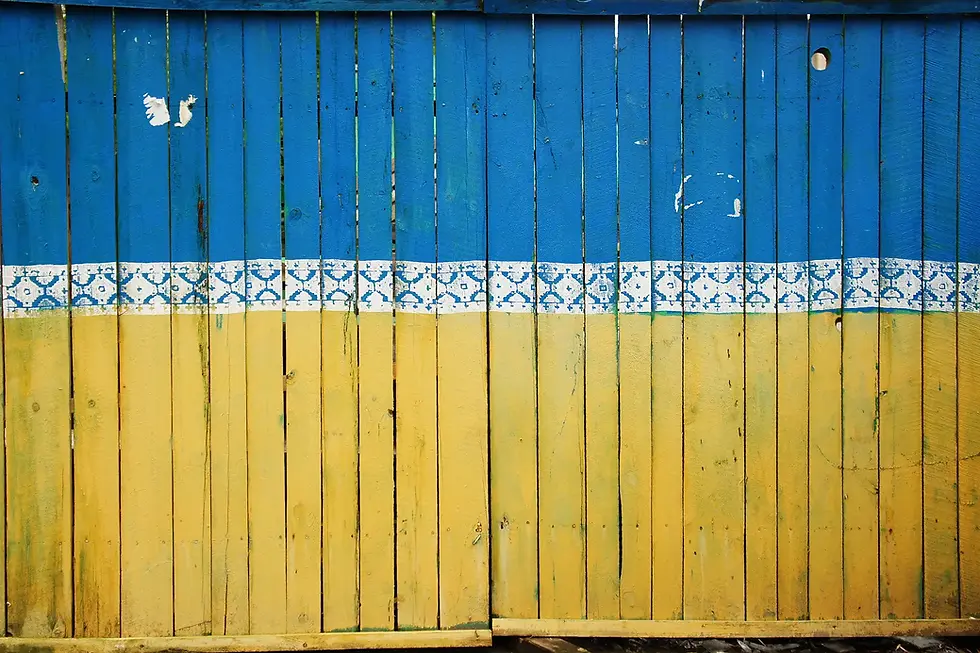 A blue and yellow wall with a wooden fence in Canada.