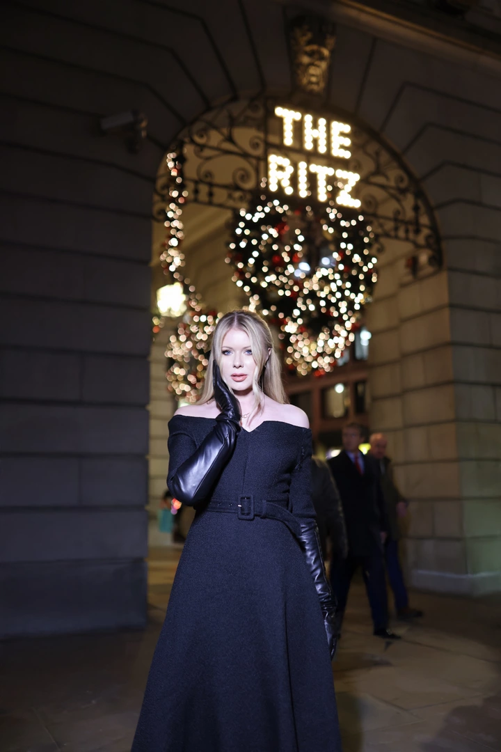 A girl poses for photos outside The Ritz Hotel