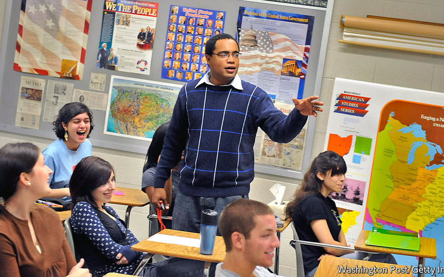 Classroom scene with a teacher speaking to engaged students.