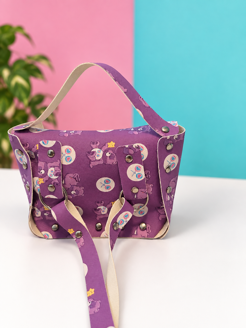 Back view of purple My Little Pony Belle bag on a pink and turquoise studio background