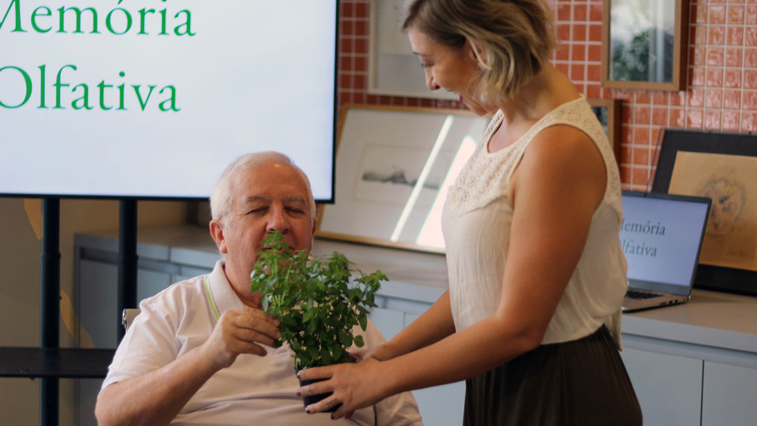 Senhor explora seu olfato na terapia em grupo para idosos com a Dra. Bianca Pascoal, psicóloga especialista em Gerontologia