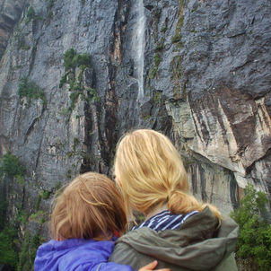 Woman and toddler looking at waterfall  on Cascading waterfall Mostraumen Fjord Cruise, Bergen