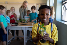 schoolboy-standing-holding-a-seedling-plant-in-a-j-MFSHW5Y.jpeg