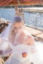 Bride holding her veil on a sailboat in sister Bay door County during her elopement wedding