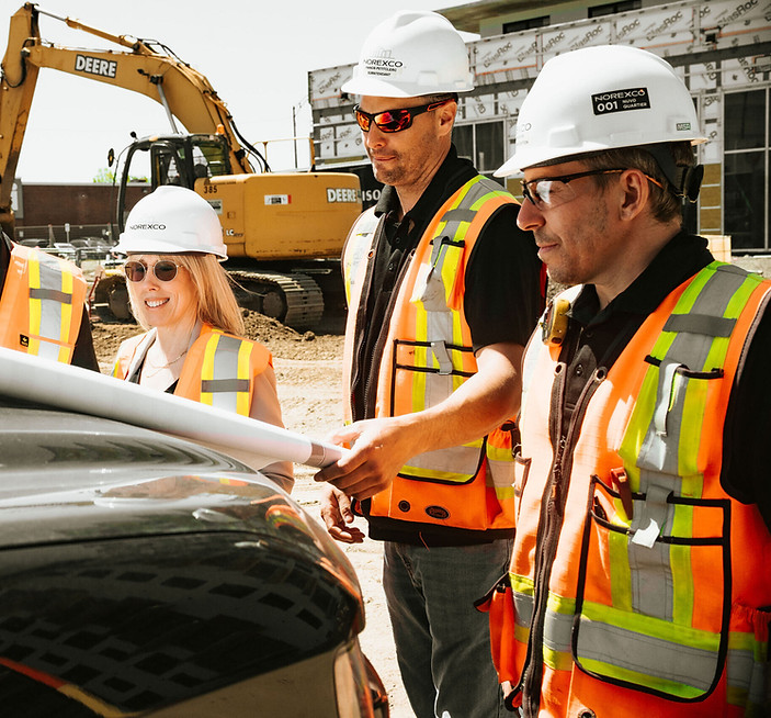 Équipe de construction Norexco analysant des plans sur un chantier au Québec