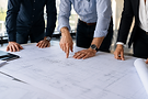 Ingénieurs et constructeurs analysant des plans de bâtiment.