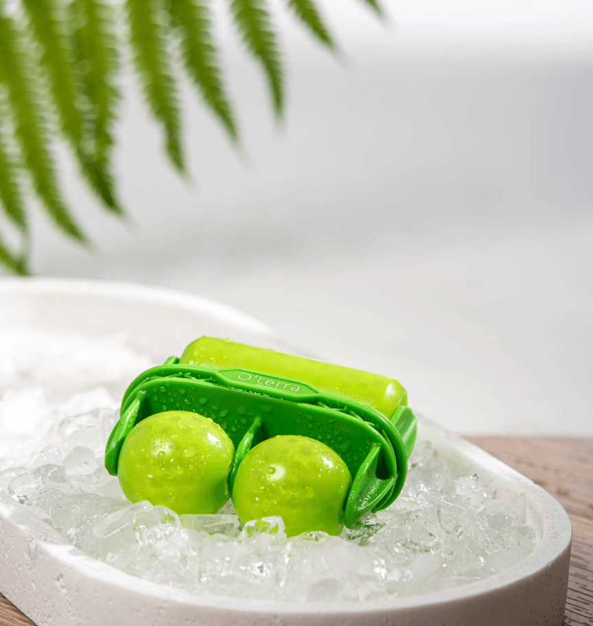 Rouleau fraîcheur O’terra vert déposé sur de la glace pour effet rafraîchissant et apaisant pour le visage.