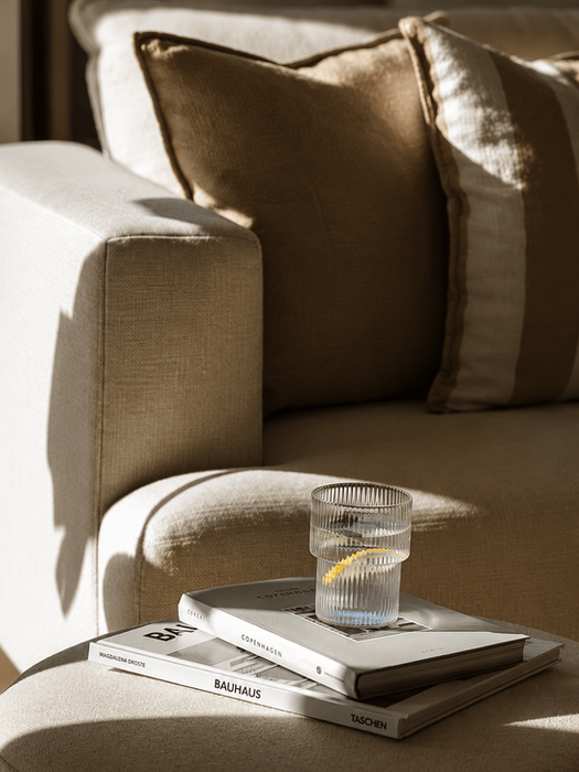 Verre d'eau citronnée sur des livres posés sur un canapé