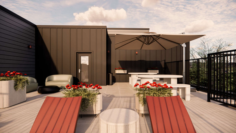 Terrasse sur le toit aménagée avec espace repas et parasol dans les condos Altitude 33 à Mirabel.