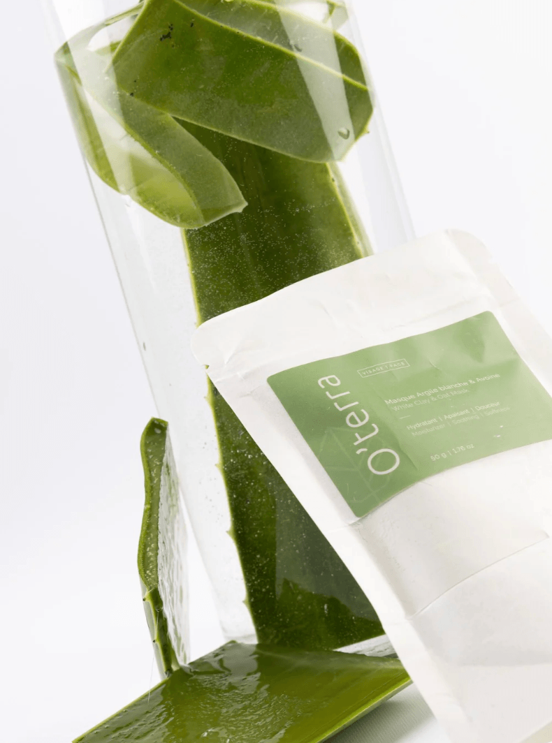 Masque à l’argile blanche et aloe vera O’terra présenté avec feuilles d’aloe vera dans un décor épuré.