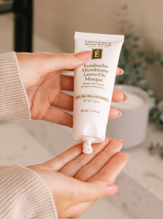 Masque sans rinçage Kombucha Microbiome d’Éminence Organic Skin Care pressé dans la main, texture crème.