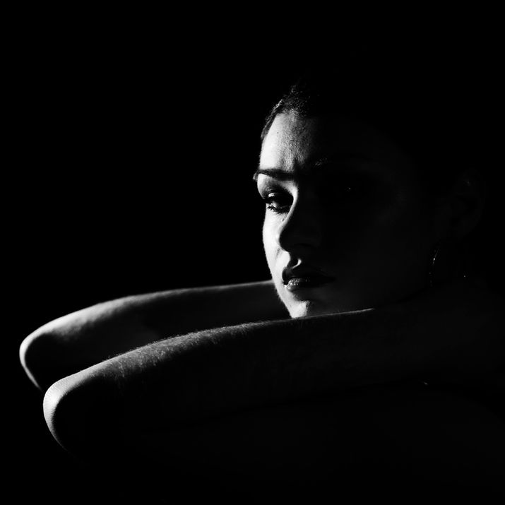 Portrait noir et blanc d’une jeune personne éclairée dramatiquement.