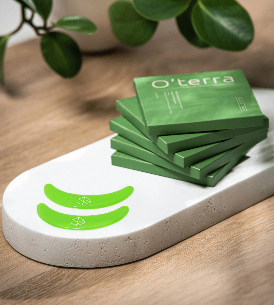 Patchs pour les yeux O’terra verts présentés avec leur emballage dans un décor naturel et minimaliste.