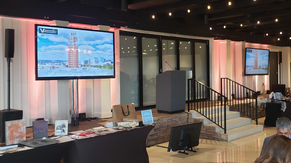 themed corporate event AV setup with two presentation screens, pink backlighting, and speaker podium with microphone