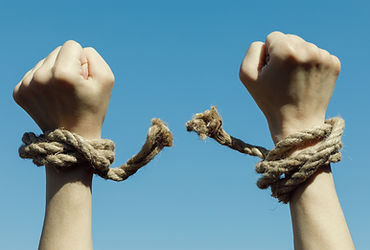 Hands tearing shackles the background of