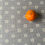 Thumbnail: Grey Flower in Circles Shweshwe with orange for scale