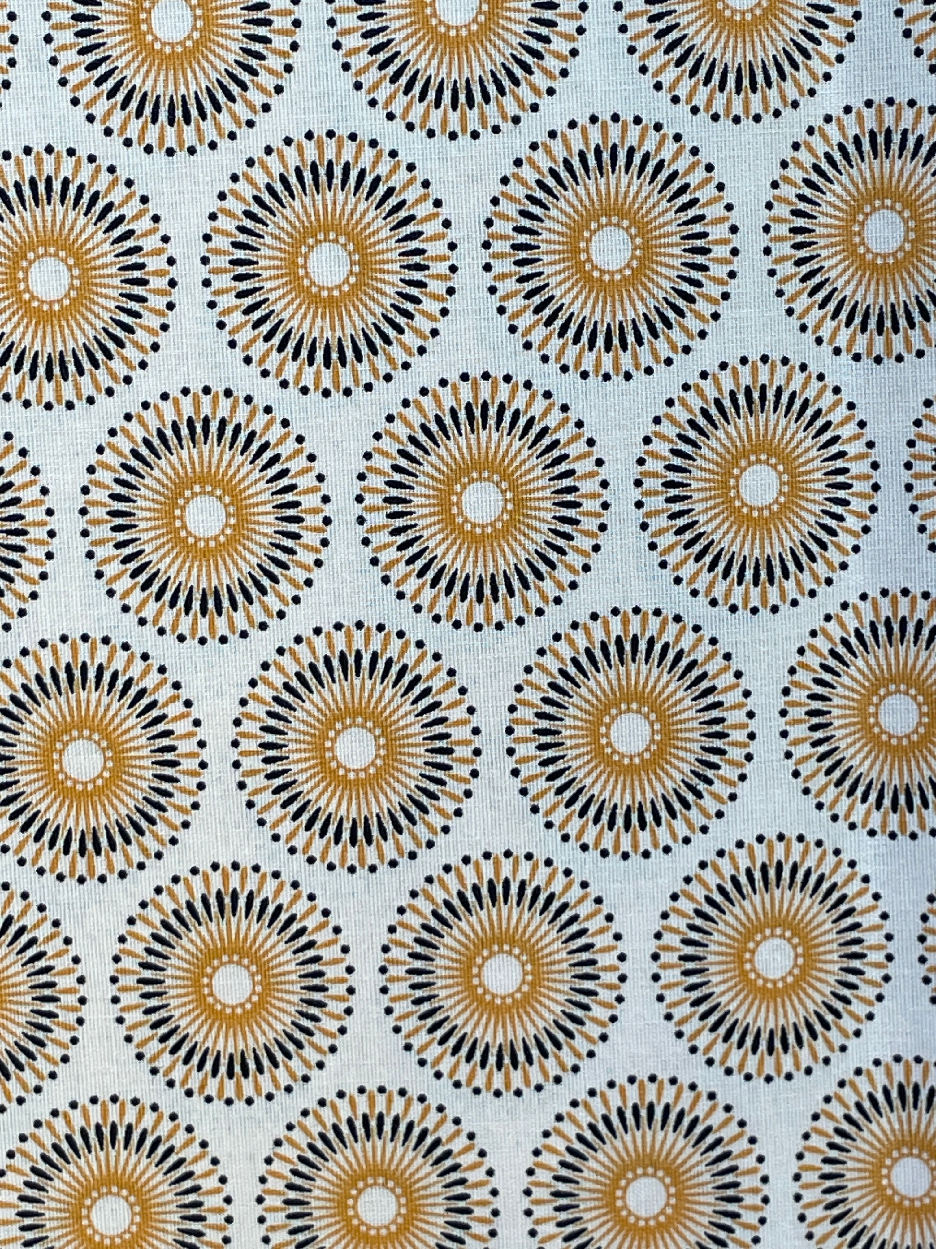 Close-up of Beige Chrysanthemums Shweshwe fabric showing ochre-gold and black chrysanthemum motifs