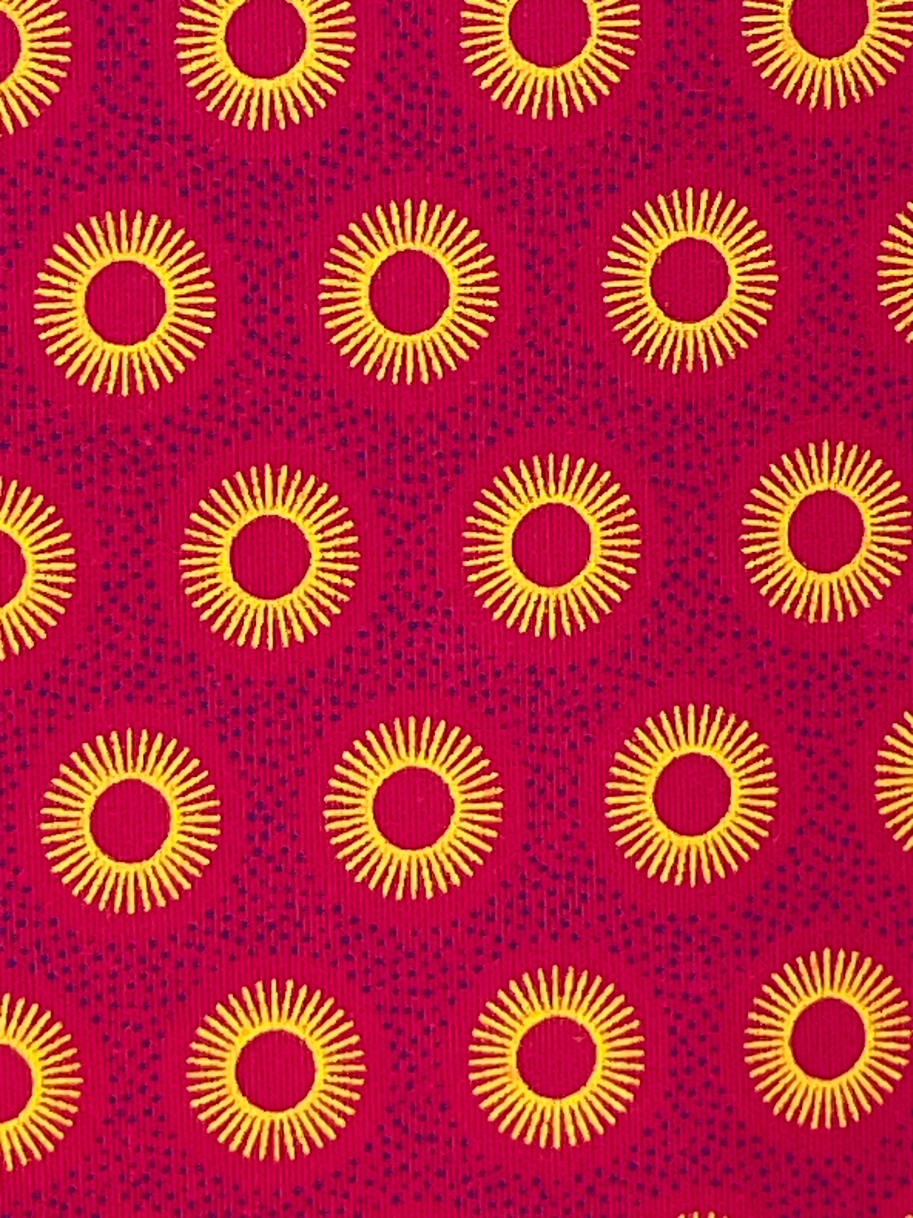 Close-up of Pink Suns Shweshwe fabric showing golden sunburst circles on vibrant pink