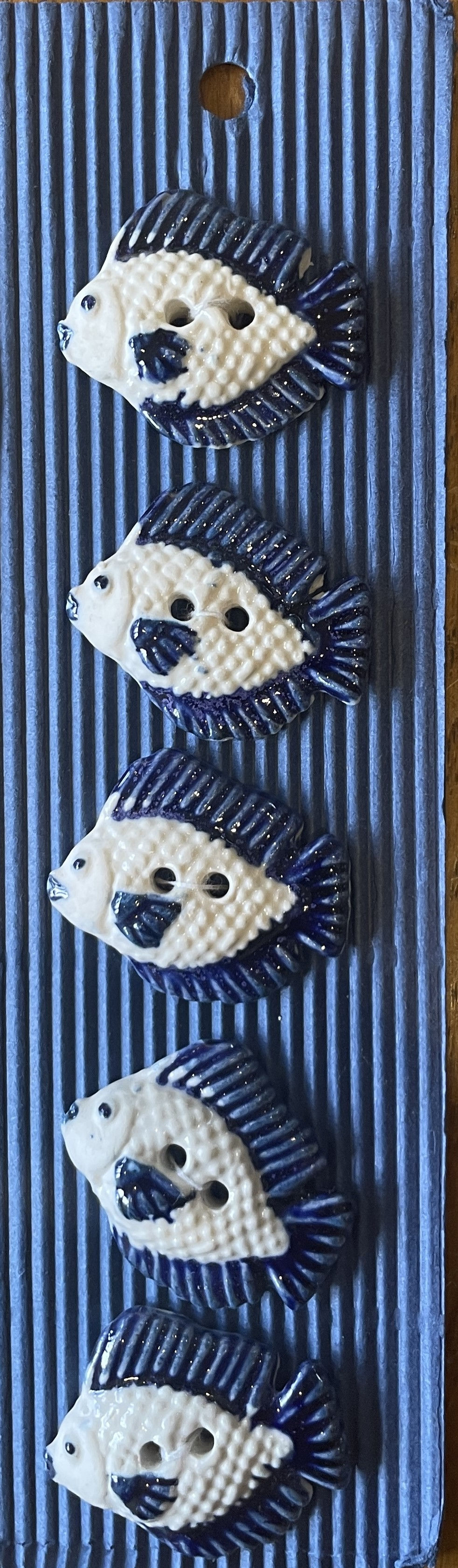Hand-painted navy and white ceramic fish buttons on card