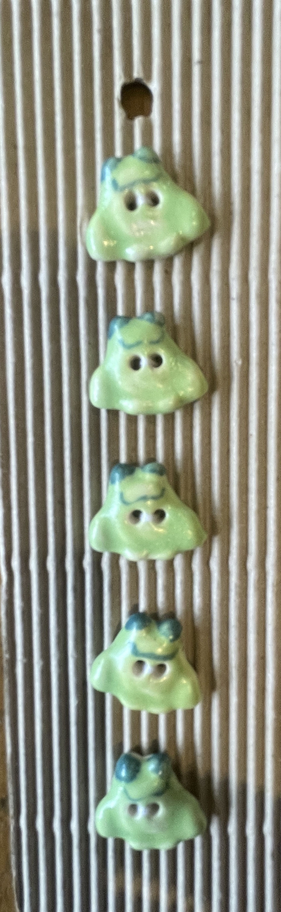 green frog sewing buttons with cartoon style design