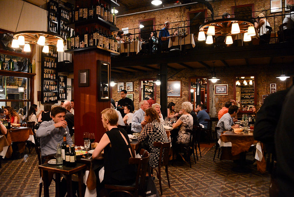 Inside a restaurant in Argentina showing people enjoying steak and wine